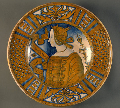 Large dish with segmental border of plant sprays and scale pattern; in the center, a profile bust of a woman in a winged headdress
